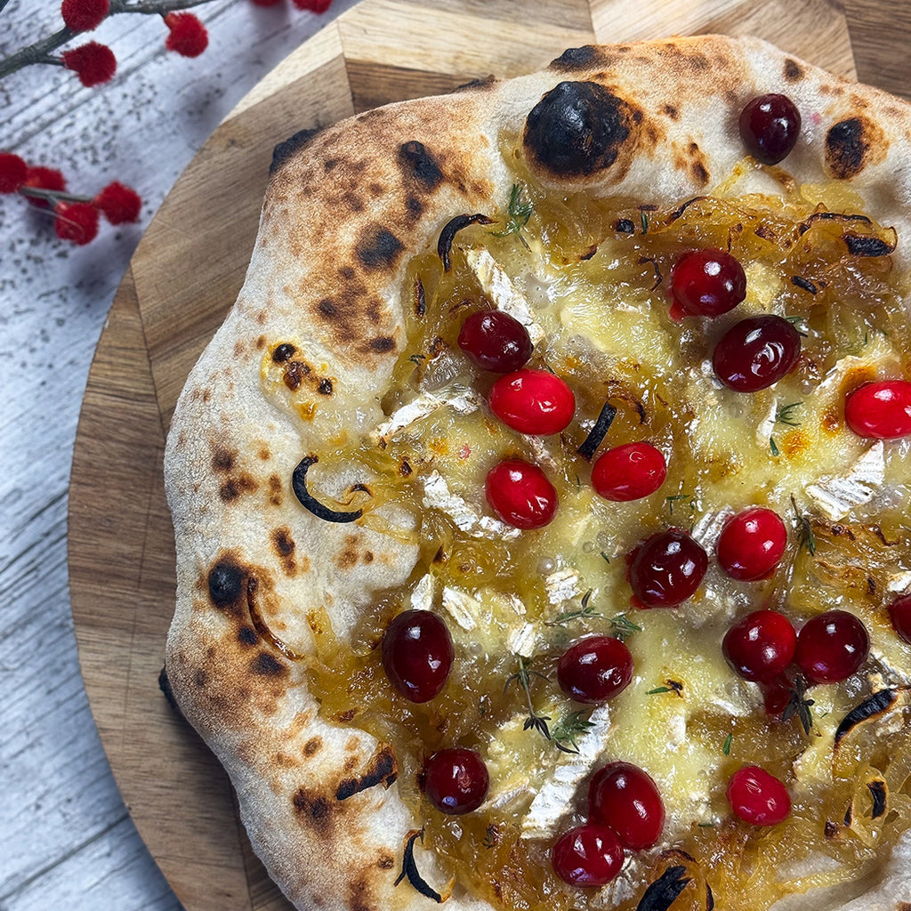 Pizza topped with caramelised onions, brie and cranberries