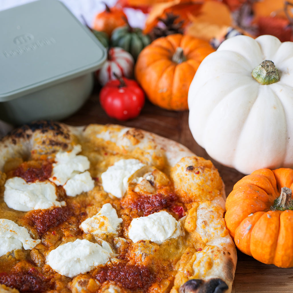 Pumpkin pizza, surrounded with mini pumpkins