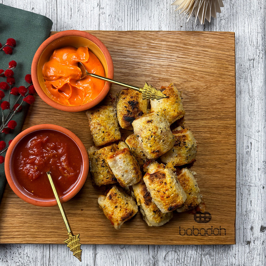 Pigs in blankets, with bowls of tomato sauce and chipotle mayo for dipping