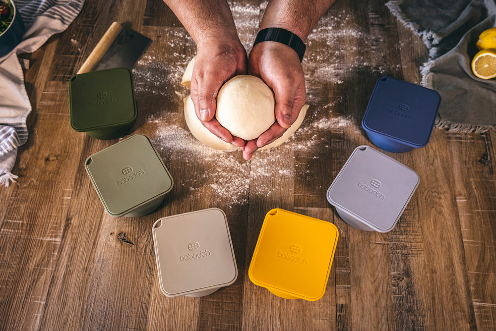 hands hugging a pizza dough ball