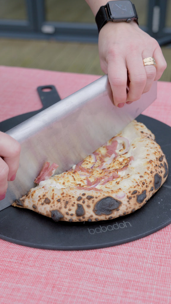 Hands slicing Alpine Pizza
