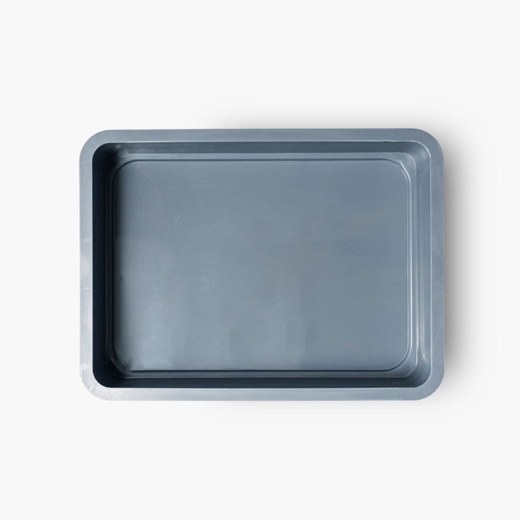 A top-down view of an empty steel-blue dough tray with a smooth, glossy surface and slightly raised edges.