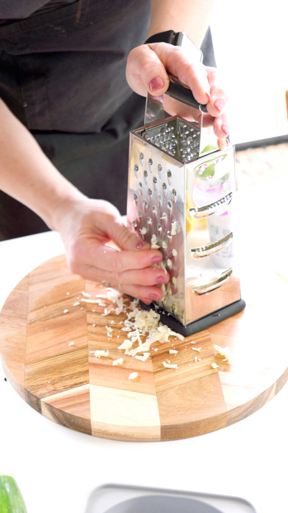 Hands grating Gruyere cheese