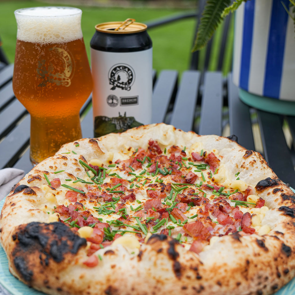 Macaroni cheese pizza with a glass of beer