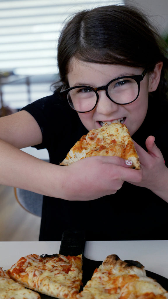 girl taking a big bite of pizza